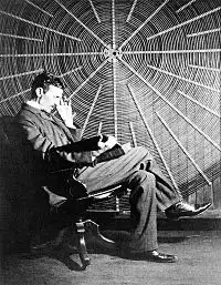 Nikola Tesla in front of the spiral coil of his high-voltage Tesla coil